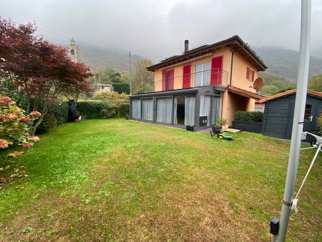 modern detached house, red shutters, brown roof, chimney, glass extension, garden, satellite dish
