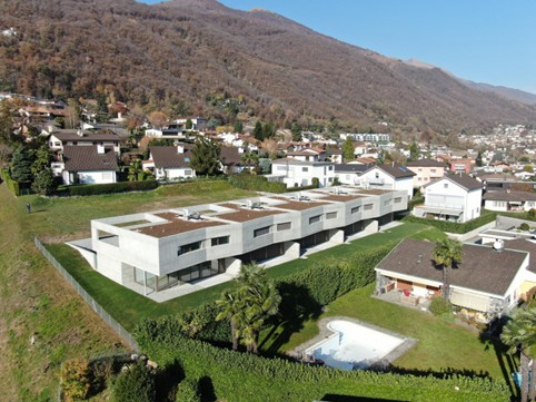 Modern apartment building, several units, swimming pool, greenery, mountainous landscape