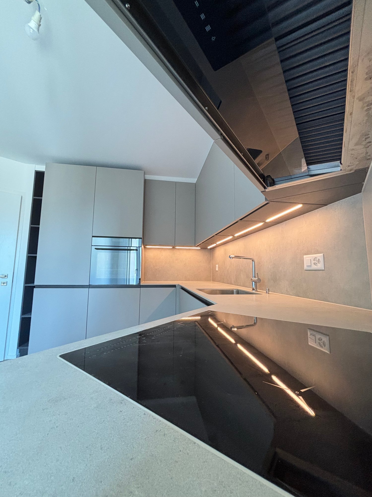 modern kitchen, gray cabinets, stainless steel appliances, gas stove, sink, countertop, under cabinet lighting, power outlet