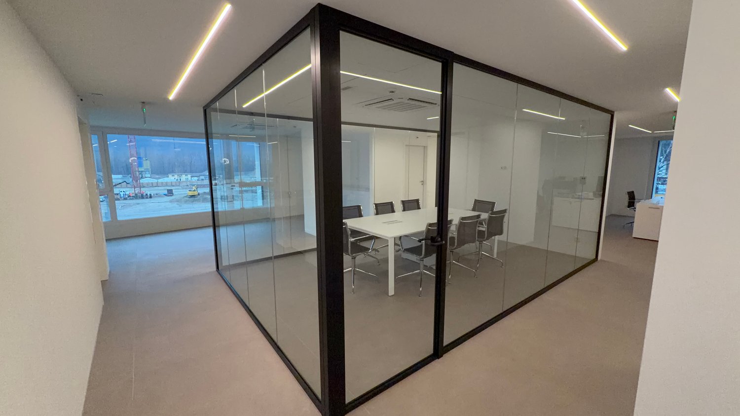 Glass walls, meeting table, modern chairs, large windows