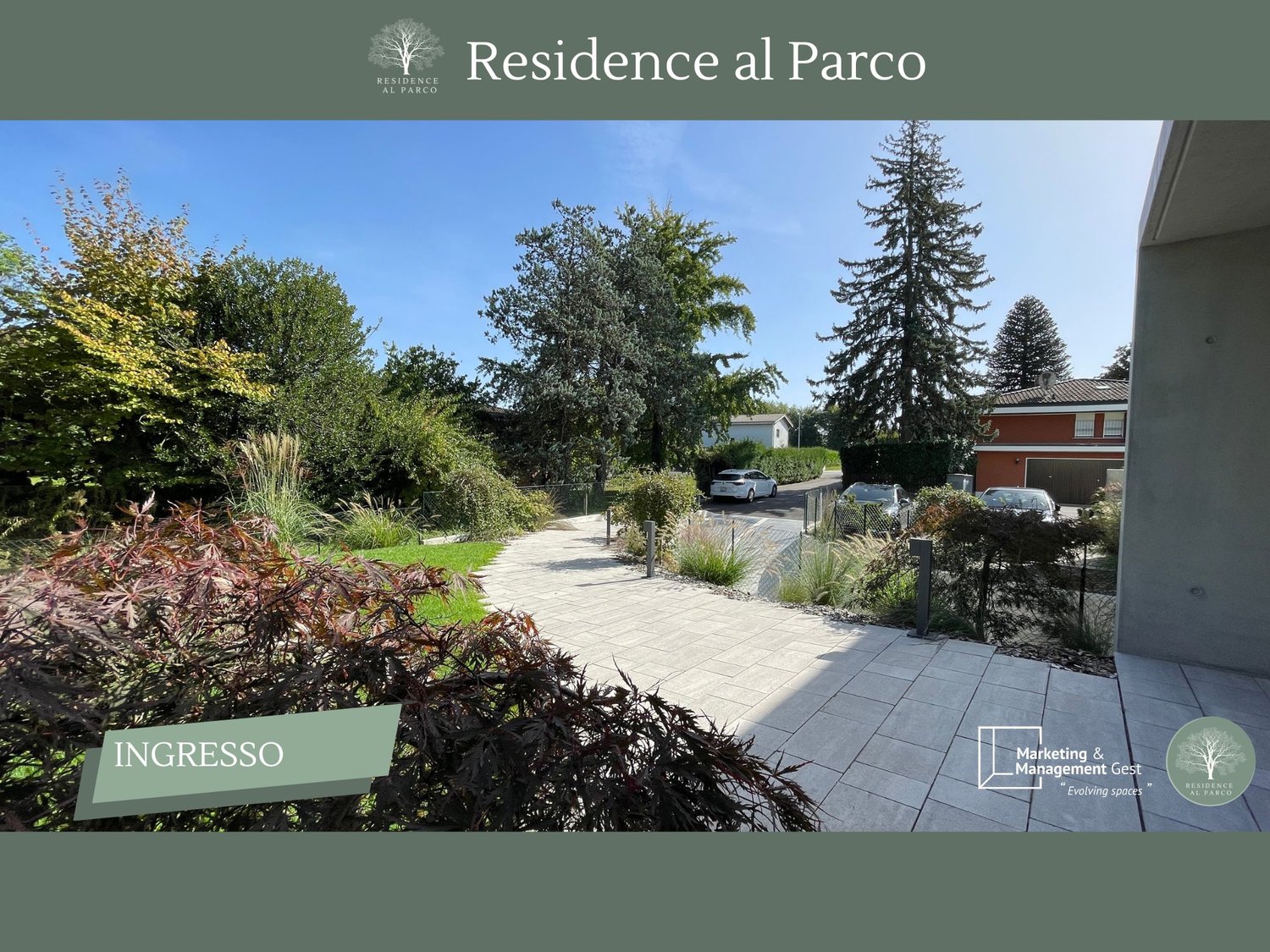 paved walkway, manicured garden, several trees and plants, several cars parked in driveway