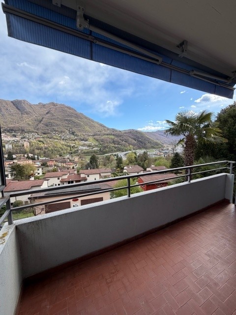 Balcony with tiled floor, metal railing, view of mountains and town