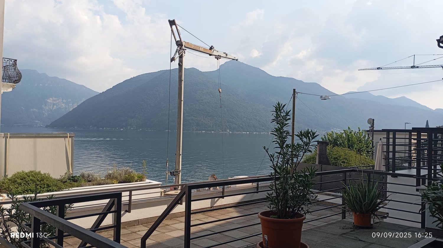Balcony with fence, large mountain in the background, water body below