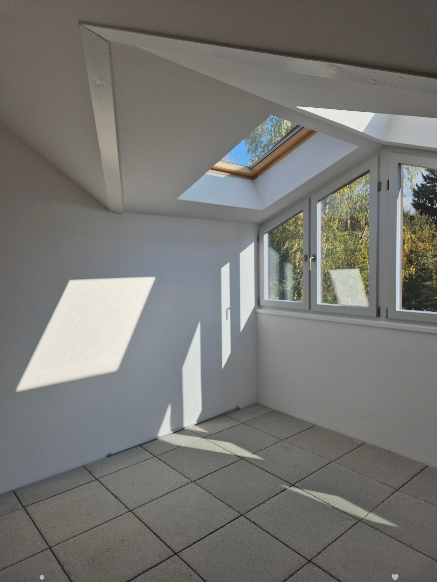 Skylight, large windows, white walls, tiled floor