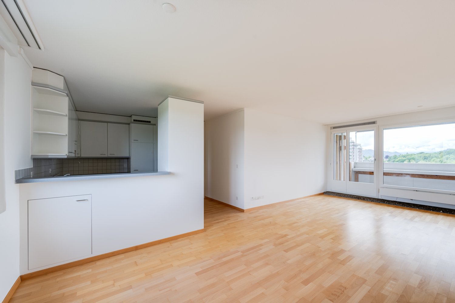 kitchen with appliances, cabinets, tiled backsplash, large windows leading to balcony