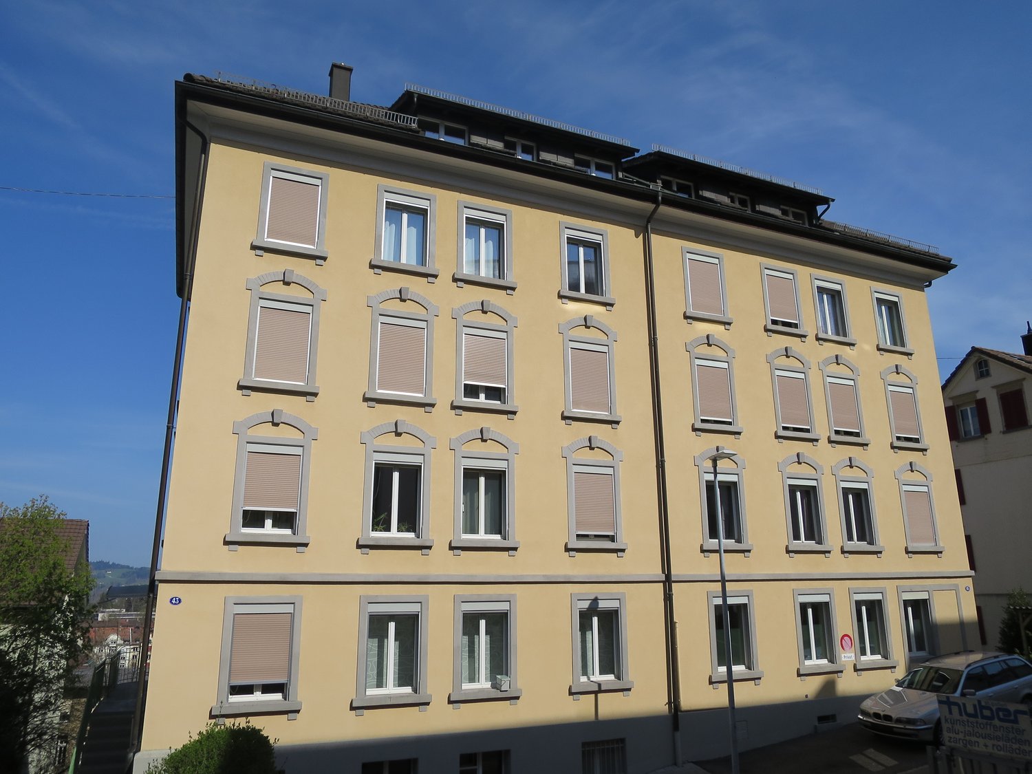 yellow facade, multiple windows, balconies, street level