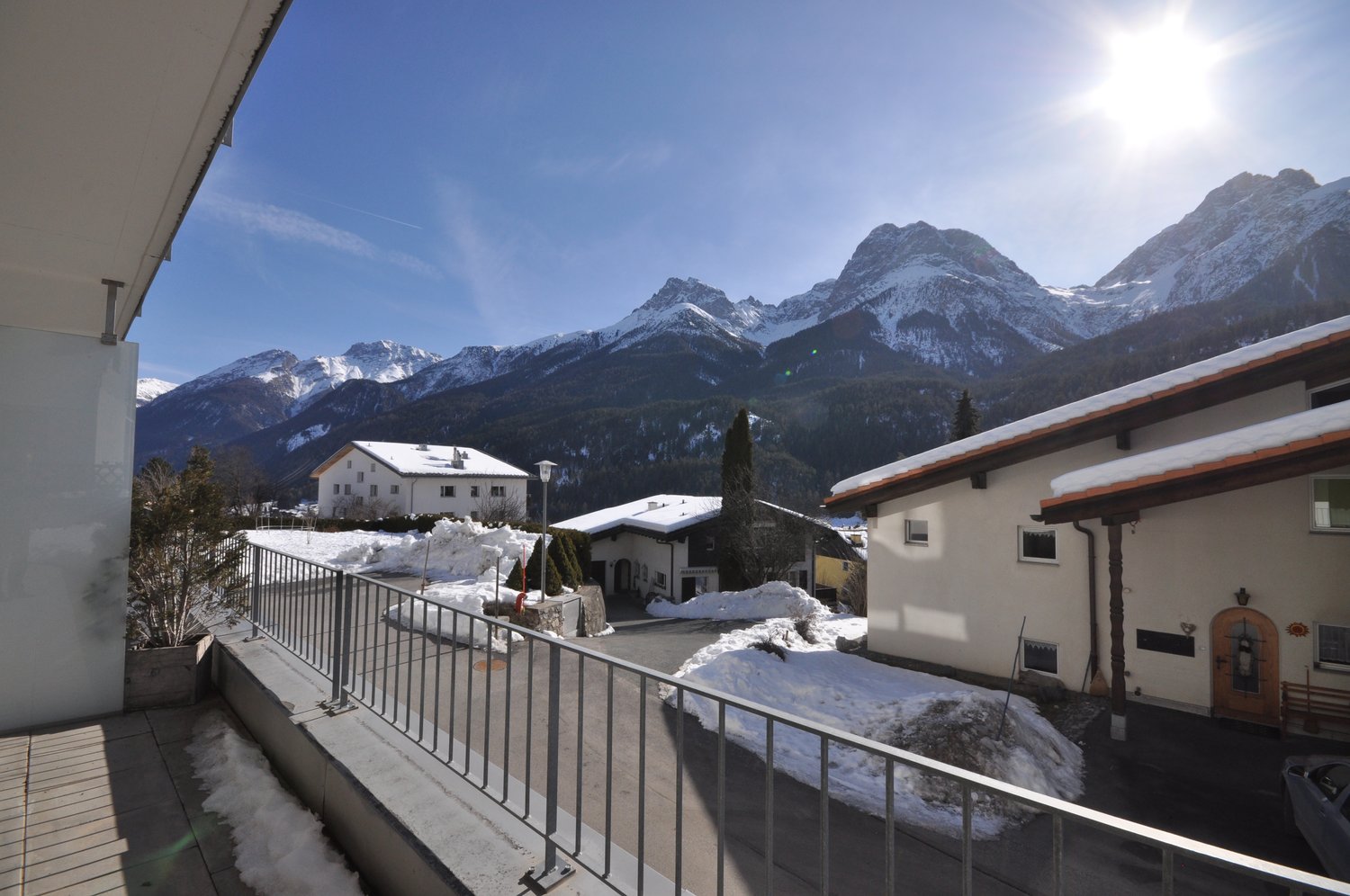 2 story house, balcony with fence, snowy mountain in the background