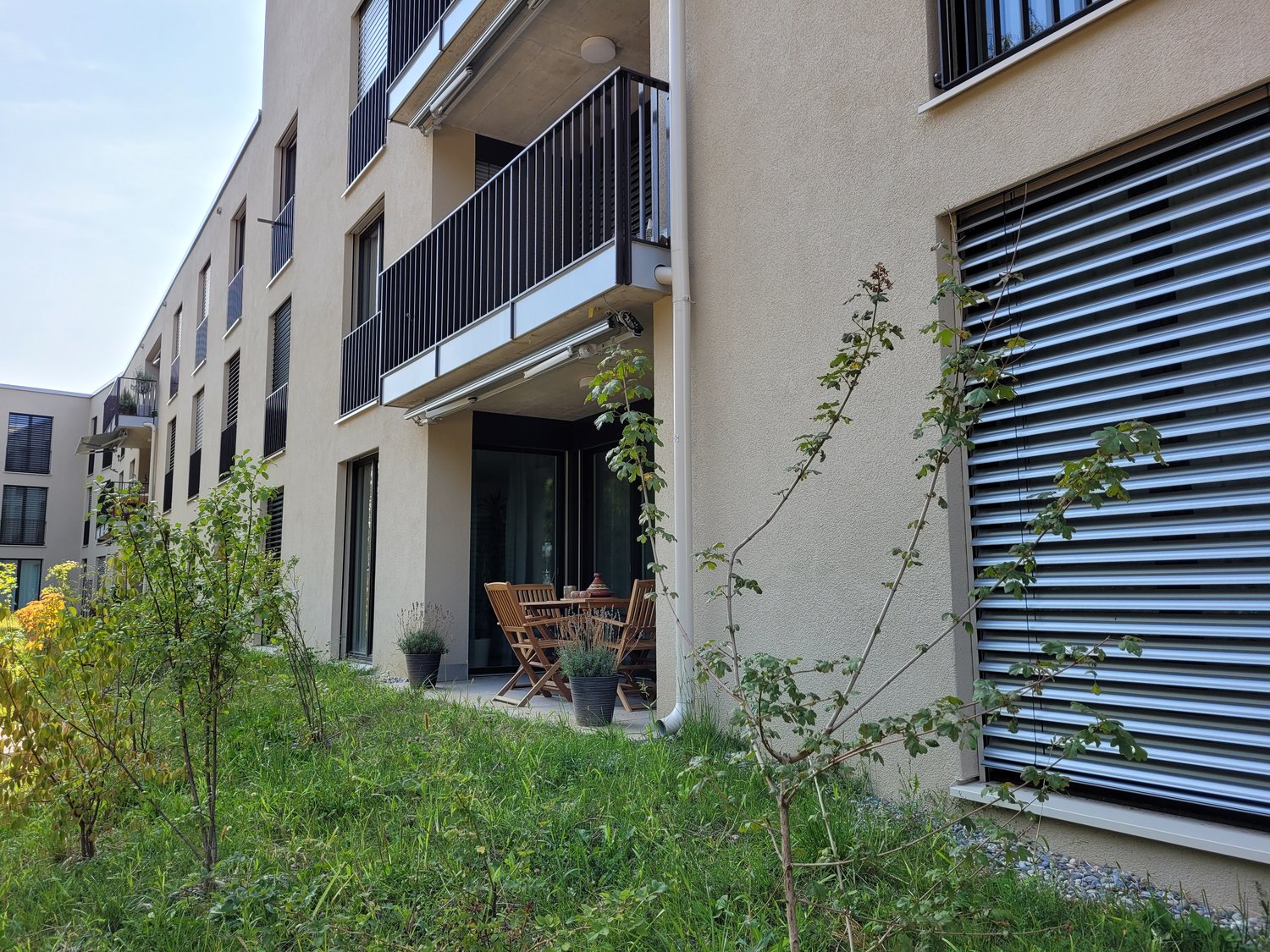 apartment entrance with garden and table, apartment building