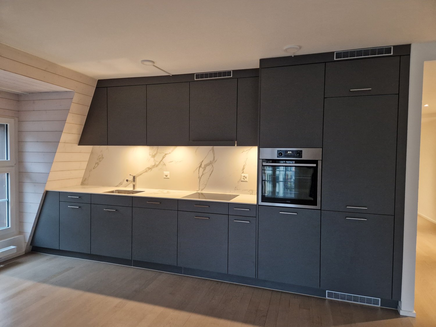 modern kitchen with gray cabinets, marble countertop, integrated appliances
