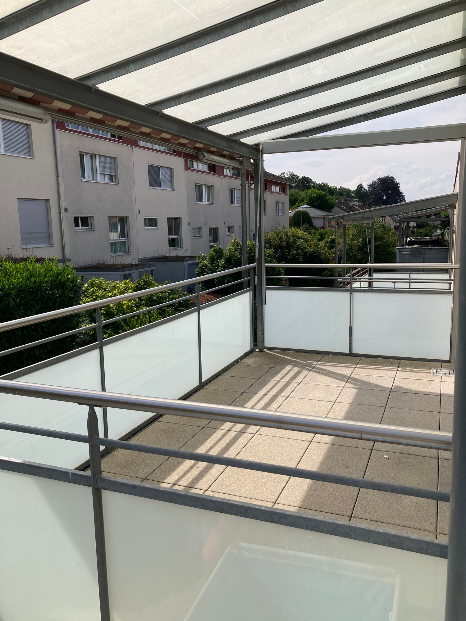 modern terrace with tiled floor, glass panels and metal railings