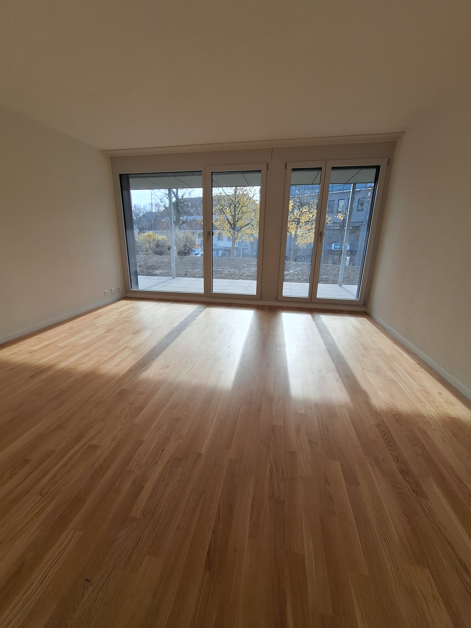 Room with large glass sliding doors, hardwood floor, balcony, empty room