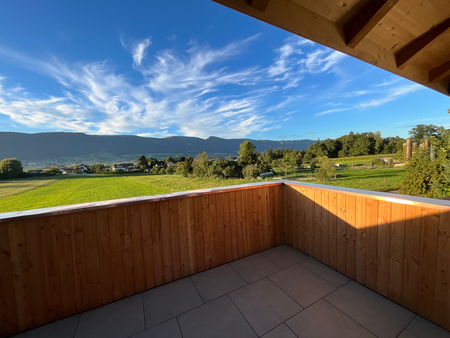 wooden balcony, tiled floor, fenced, wide view of countryside