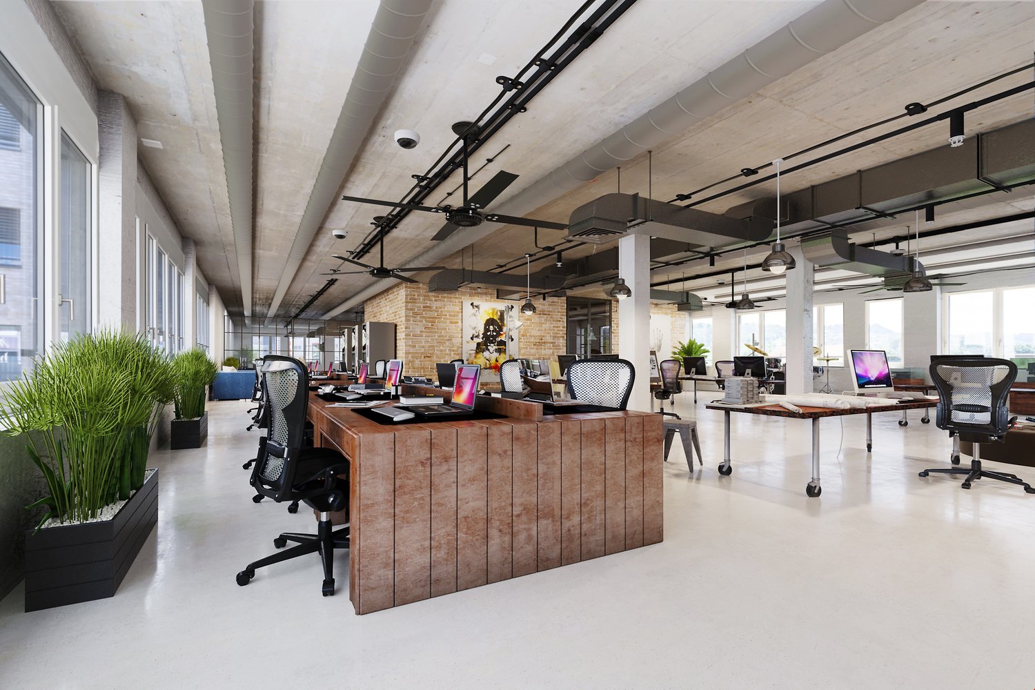 modern open space office with desks, monitors, ceiling fans, brick accent wall, white floors, various plants
