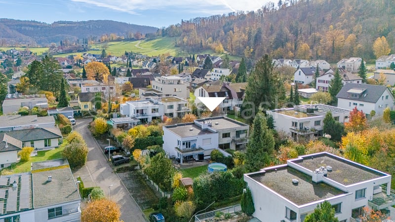 aerila view of neighbourhood with buildings in hills, gardens and trees