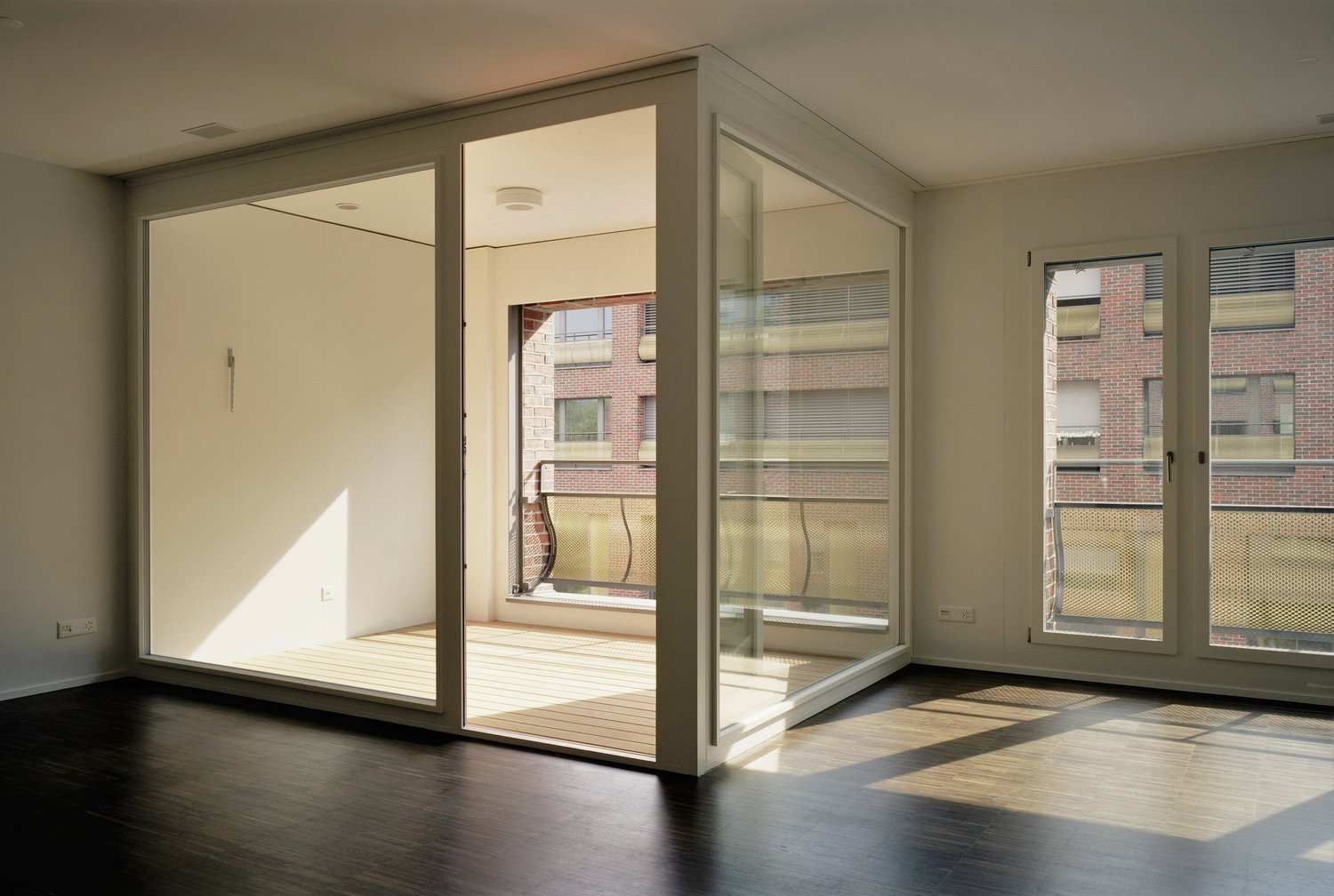 empty room, wooden flooring, sliding glass doors, balcony with metal railing