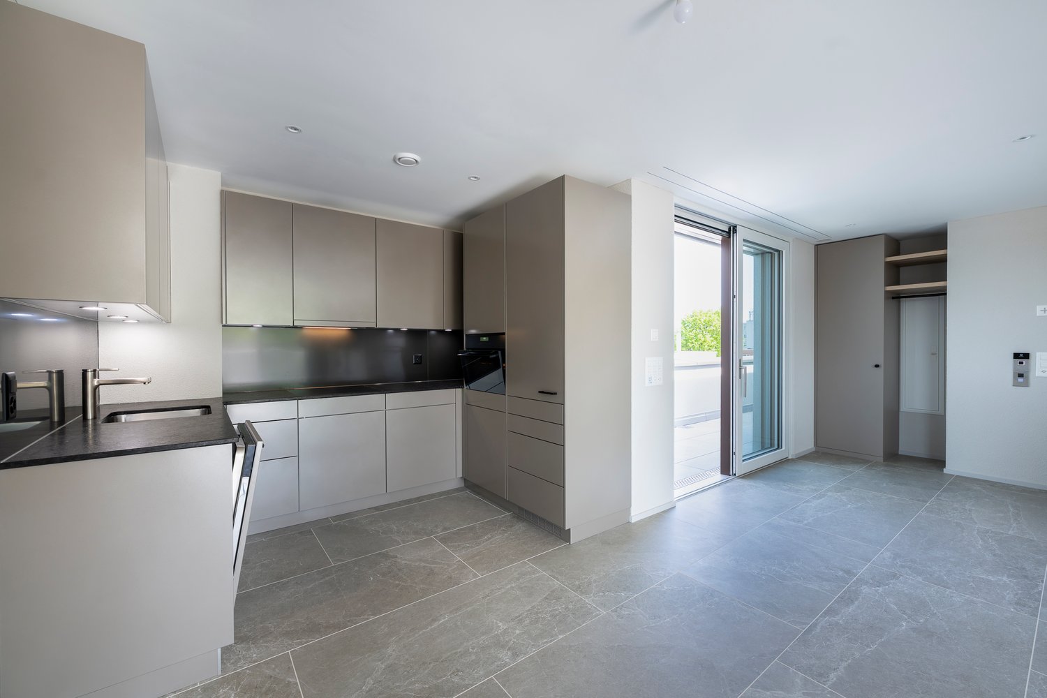 modern kitchen, gray cabinets, granite countertops, integrated appliances, sliding glass door