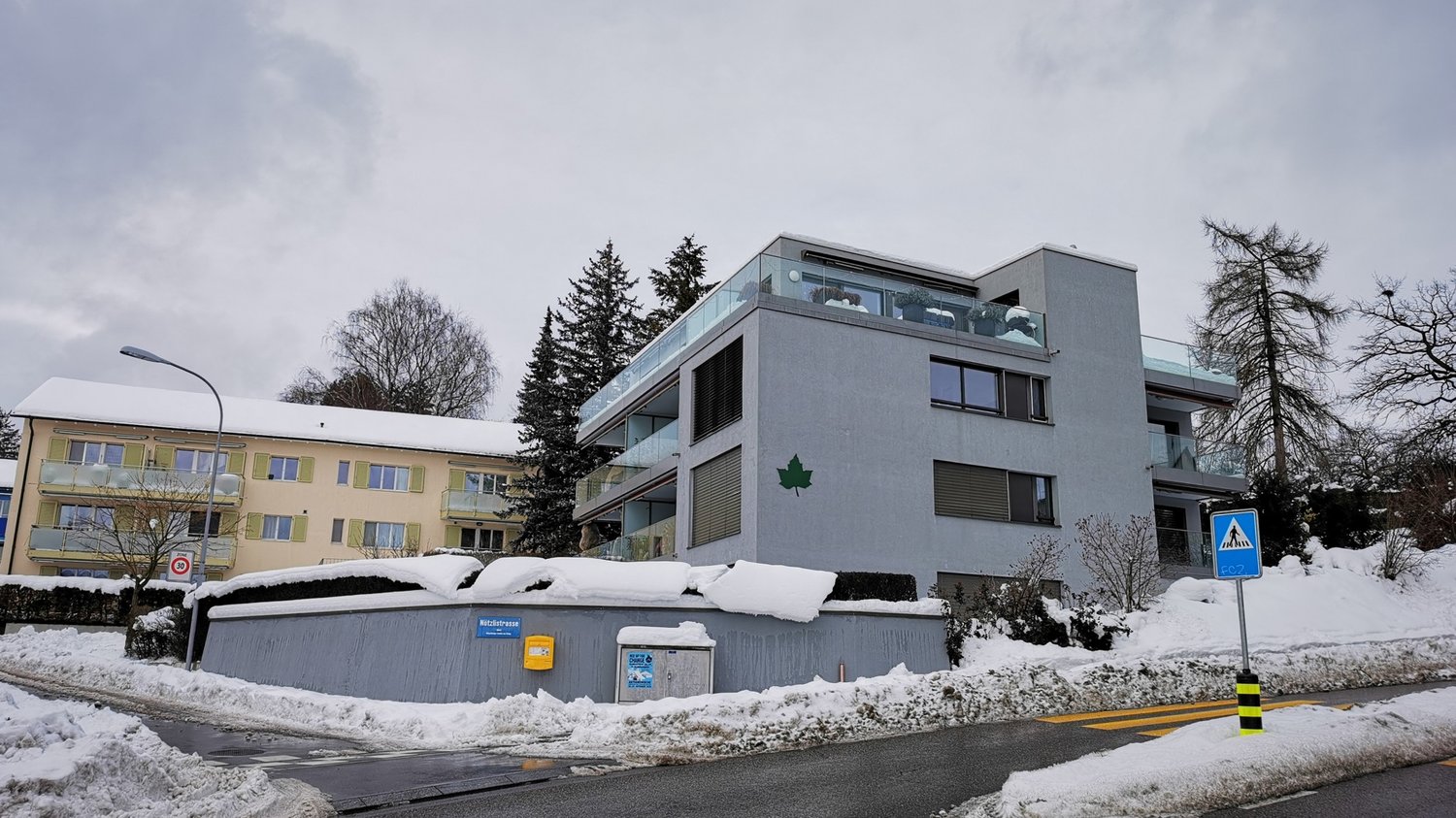 Two story house, snow cover, balcony, windows, wall letter
