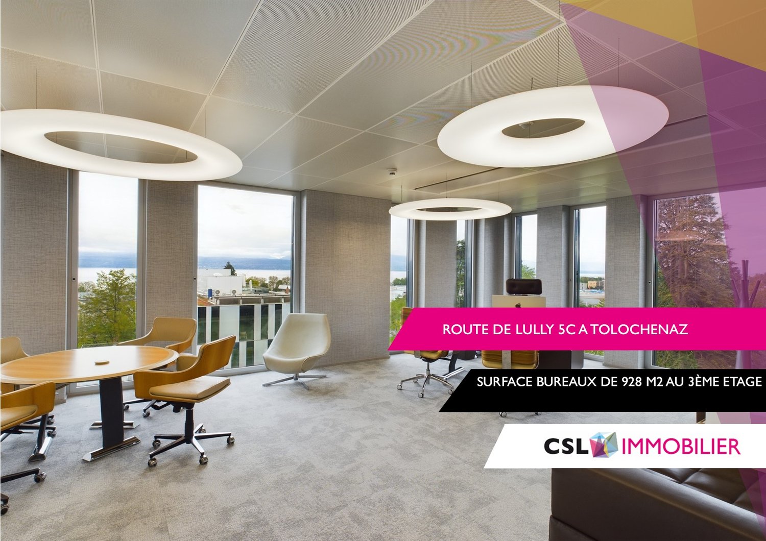 Large open office space with floor-to-ceiling windows offering a scenic view, modern furniture including round tables and swivel chairs, and colorful lighting fixtures on the ceiling.