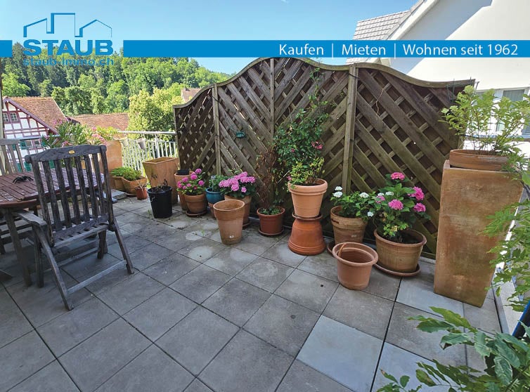 balcony with tiled floor, various potted plants, wooden fence, wooden chair, wooden table, wooden planter