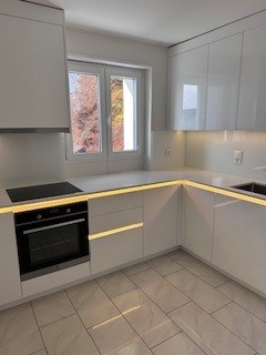 Kitchen with white cabinetry, tile flooring, integrated appliances, yellow LED strip lighting