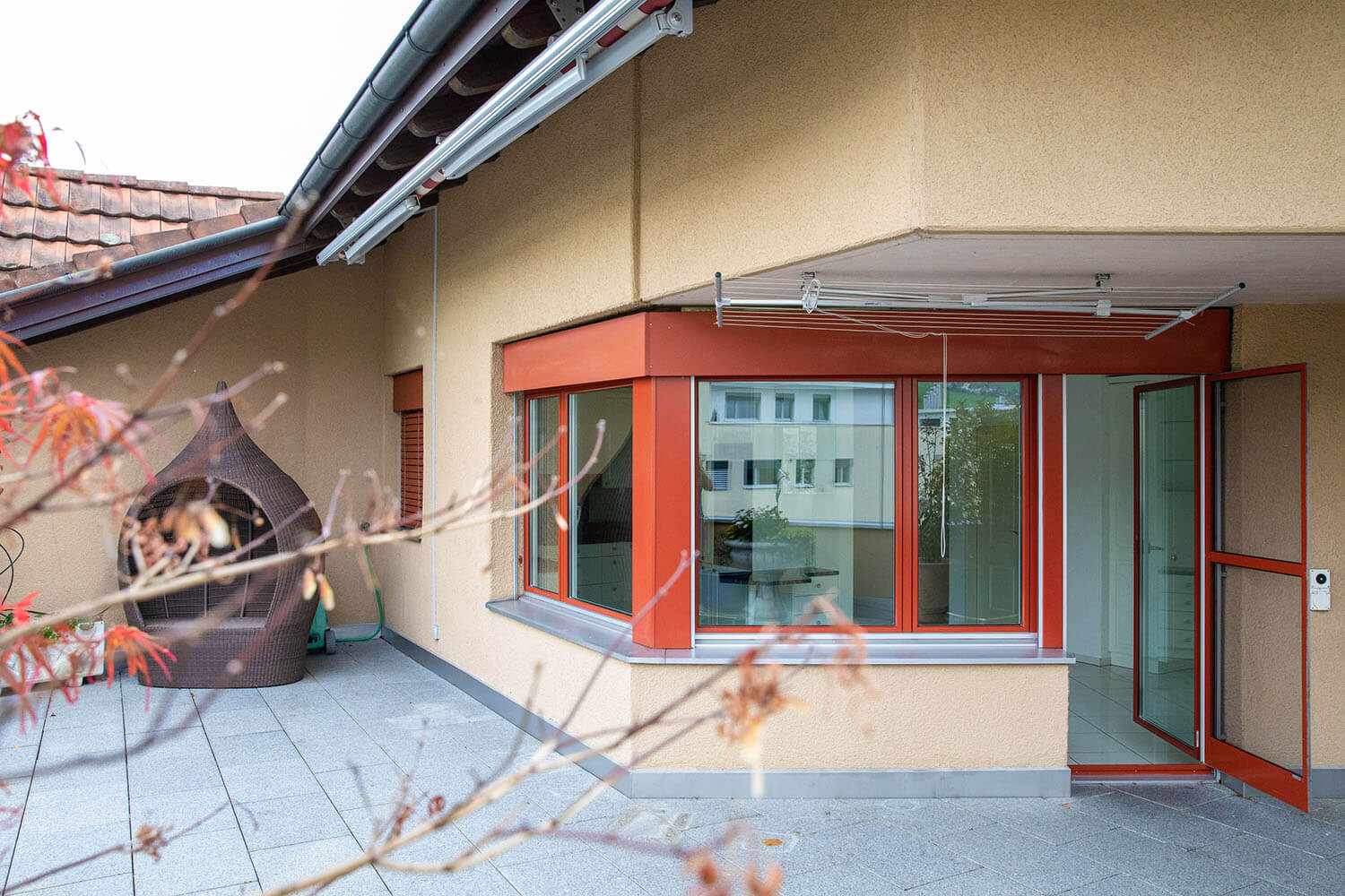 A balcony with a fireplace and double glass doors to a room
