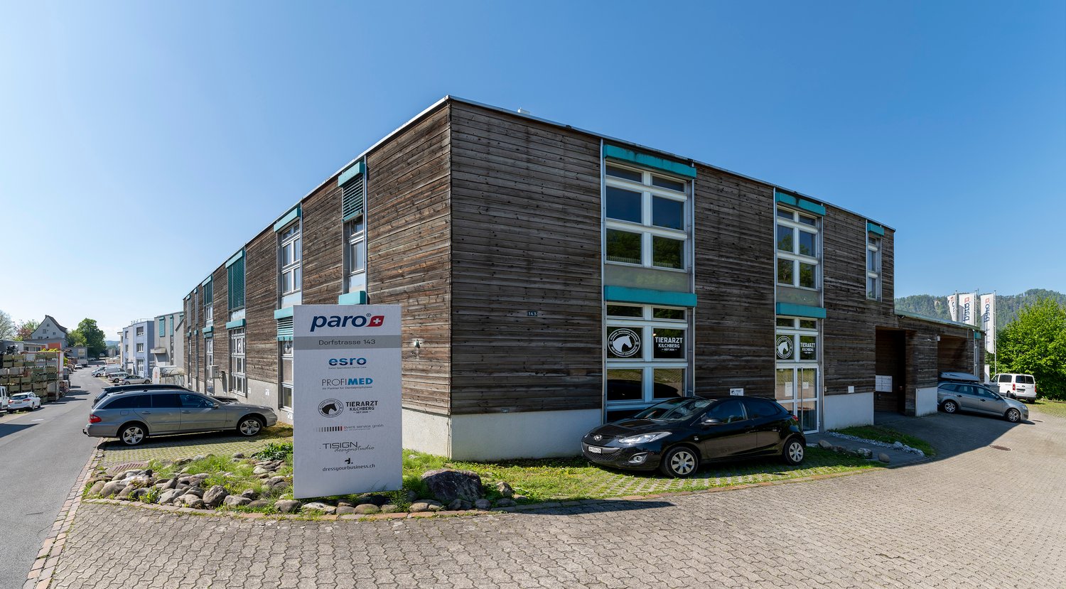 Commercial building, wood paneling, brick flooring, windows, cars parked in front
