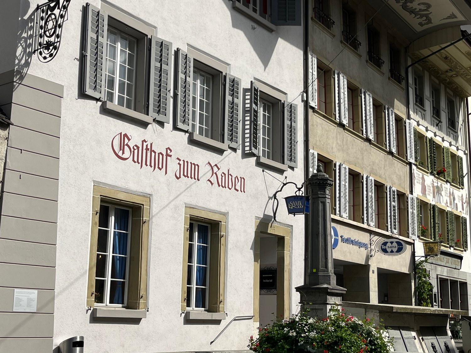 Facade of a traditional building with several windows and red lettering 'Balthor zum Raben'.