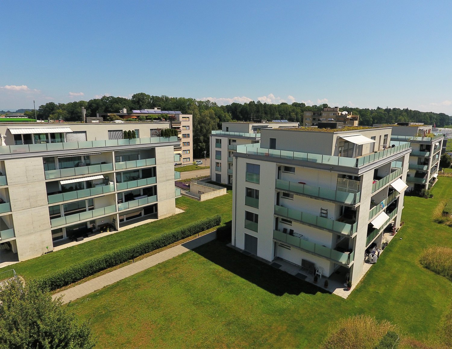 Several apartment buildings with balconies, parking, landscaped gardens