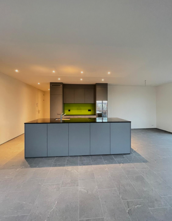 modern kitchen, central island with faucet, gray cabinets, large black counter top, yellow under cabinet lighting