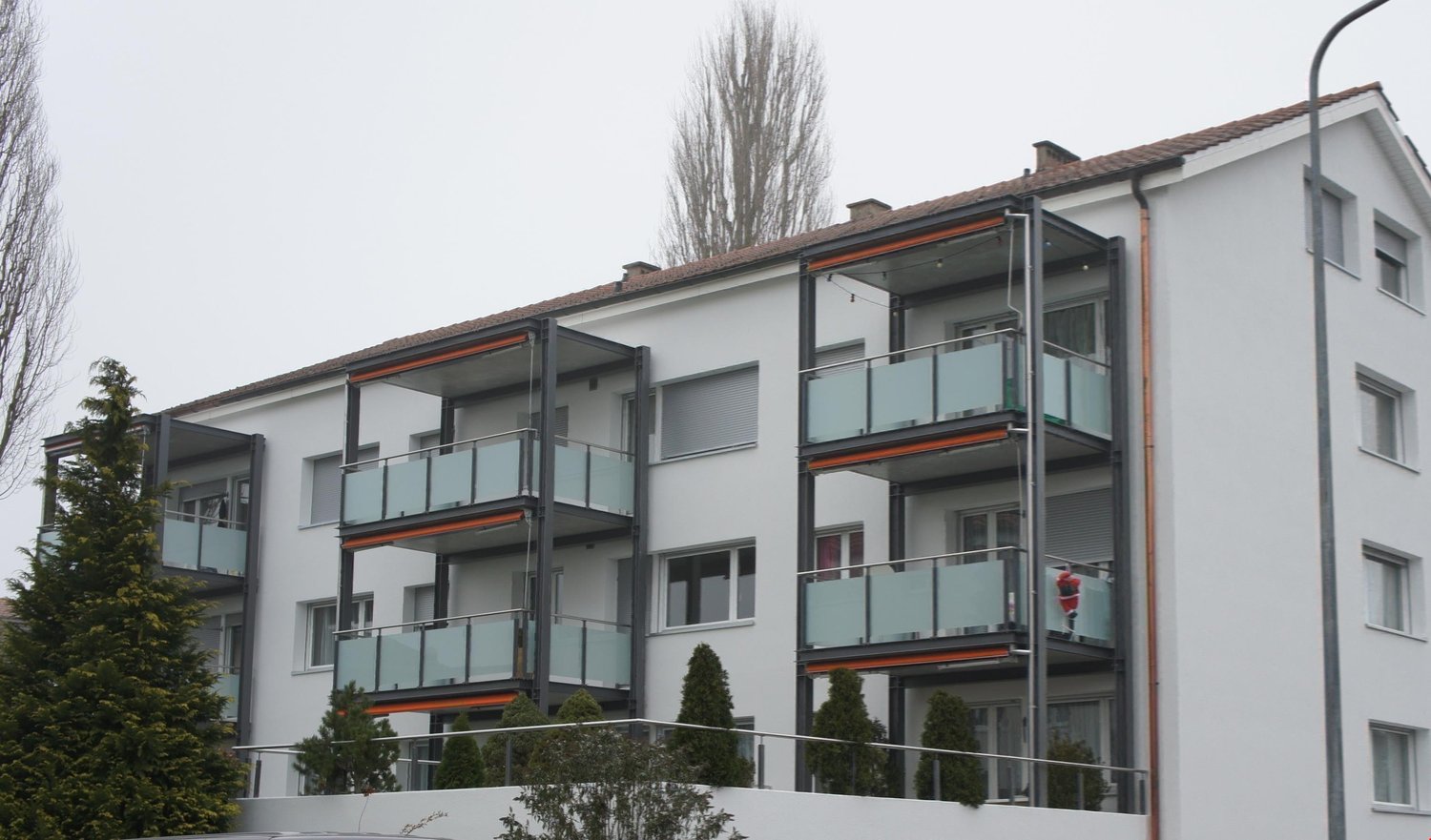 white apartment building, 4 stories, multiple balconies