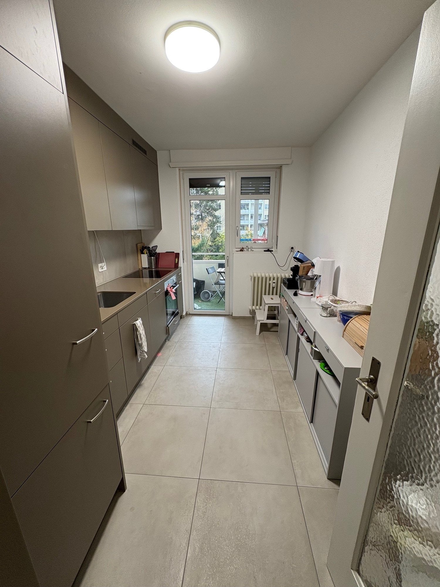 modern kitchen with a table, oven, microwave, and fridge