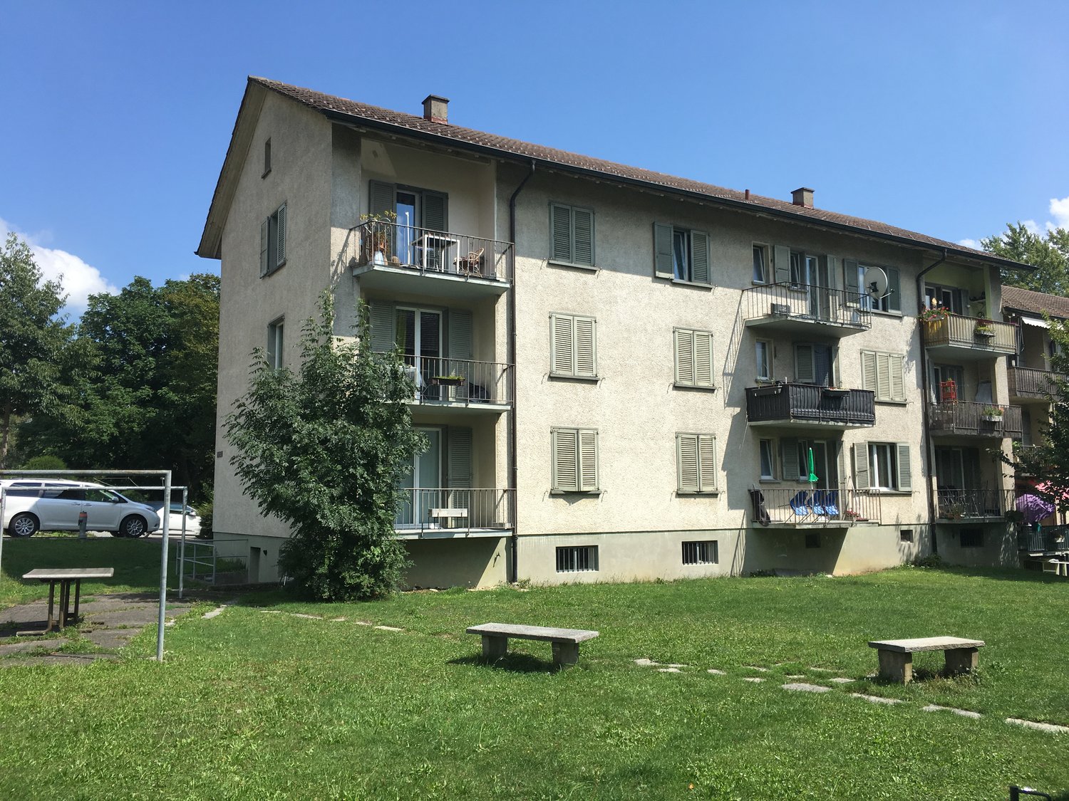 Apartment building, balconies, tree, grassy area