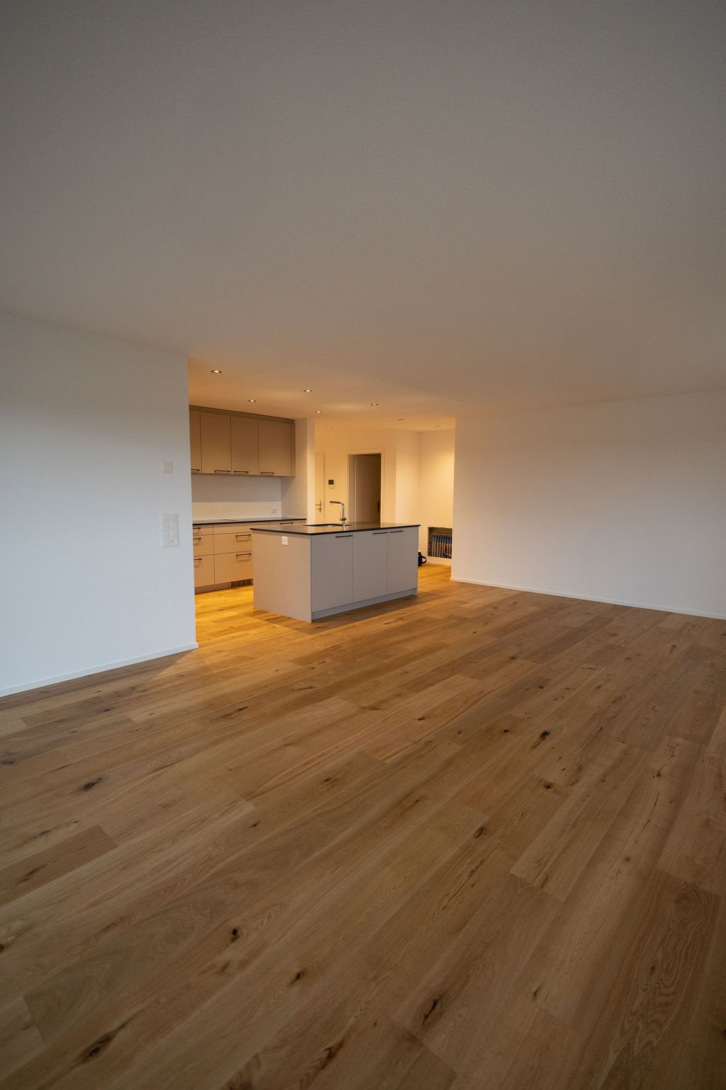 empty room, kitchen, island countertop, sink, wooden floor, white walls
