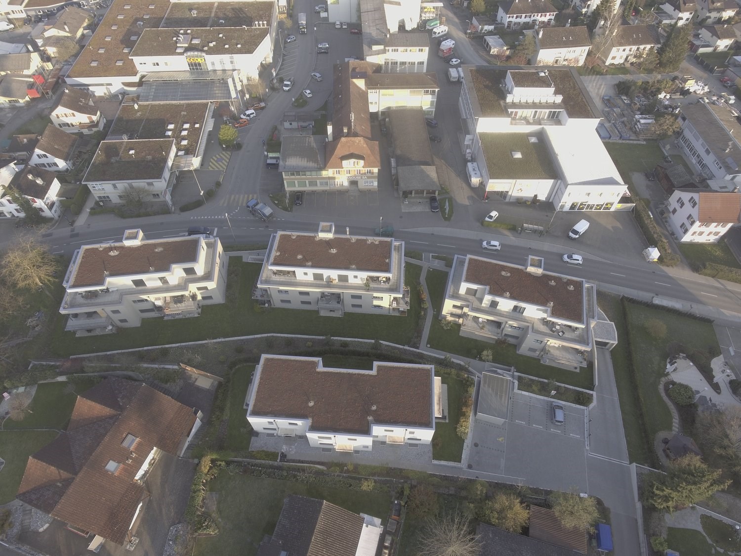 This image shows an aerial view of a city or town. The image depicts a densely populated urban area with various buildings, streets, and roads. The buildings appear to be a mix of residential and commercial structures, with some larger buildings and small