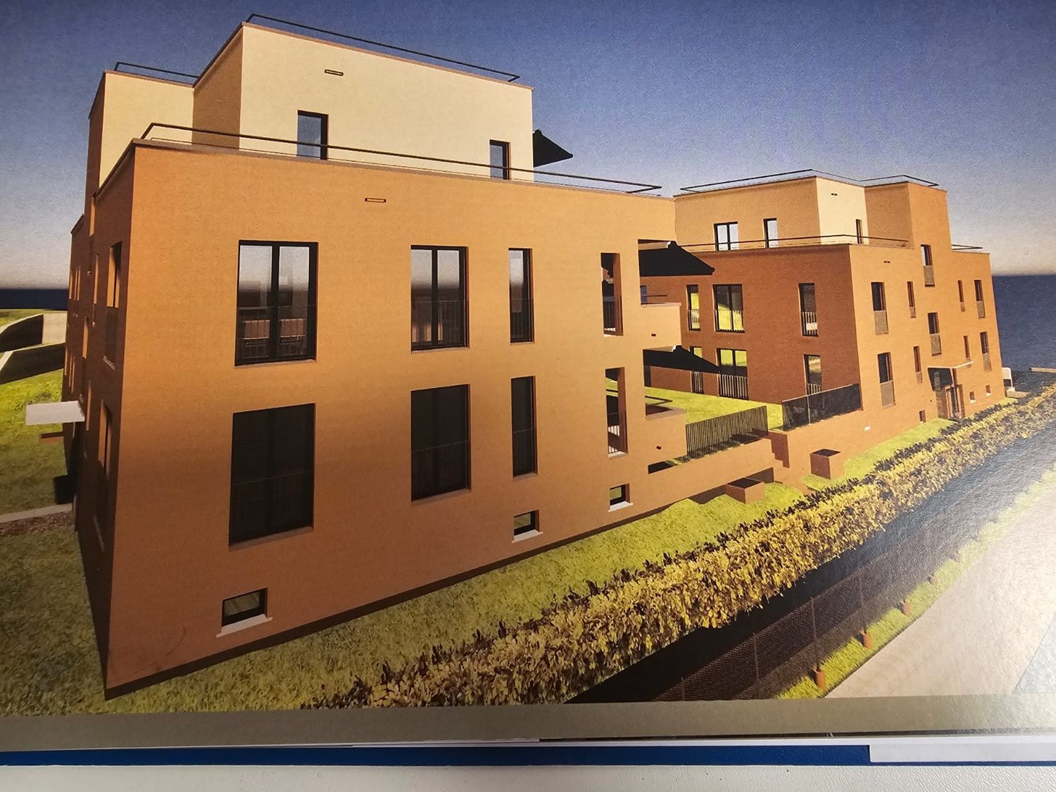 modern multi-story building, beige exterior, large windows, balconies, rooftop terrace