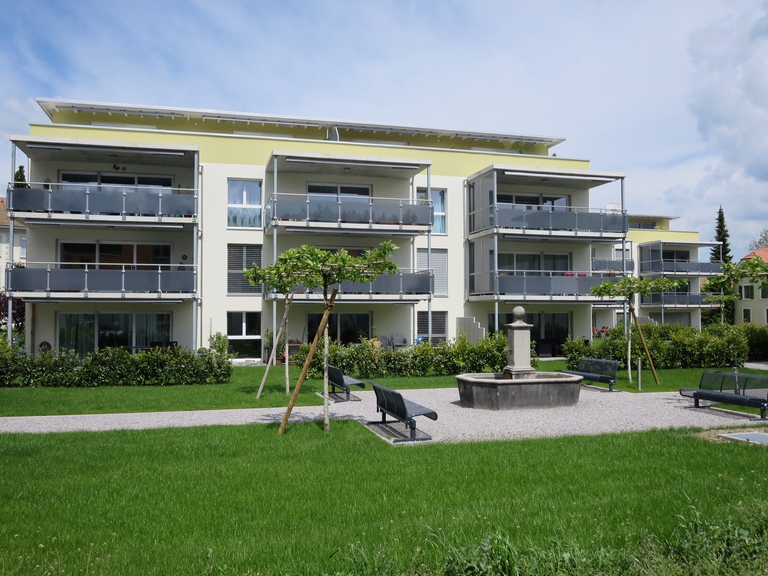 Multi-story building, balconies, common garden, benches, fountain