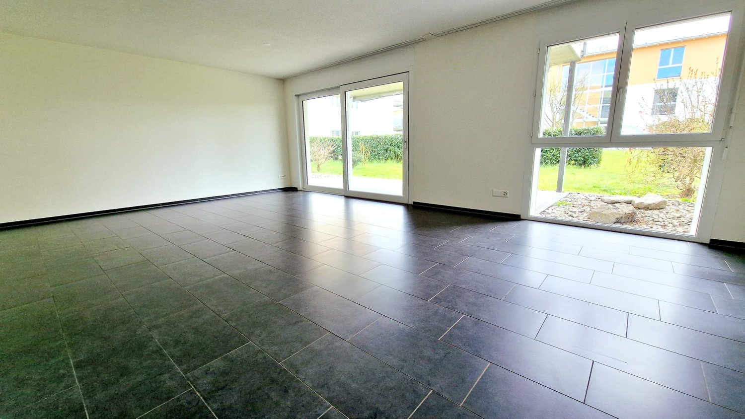 empty room, green tile floor, sliding doors, large windows