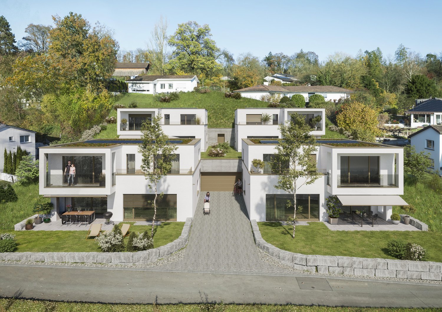 The image shows a modern residential complex with multiple two-story townhouse-style units. The buildings have a clean, minimalist design with large windows and balconies. The complex is surrounded by lush greenery, including trees and landscaped gardens.