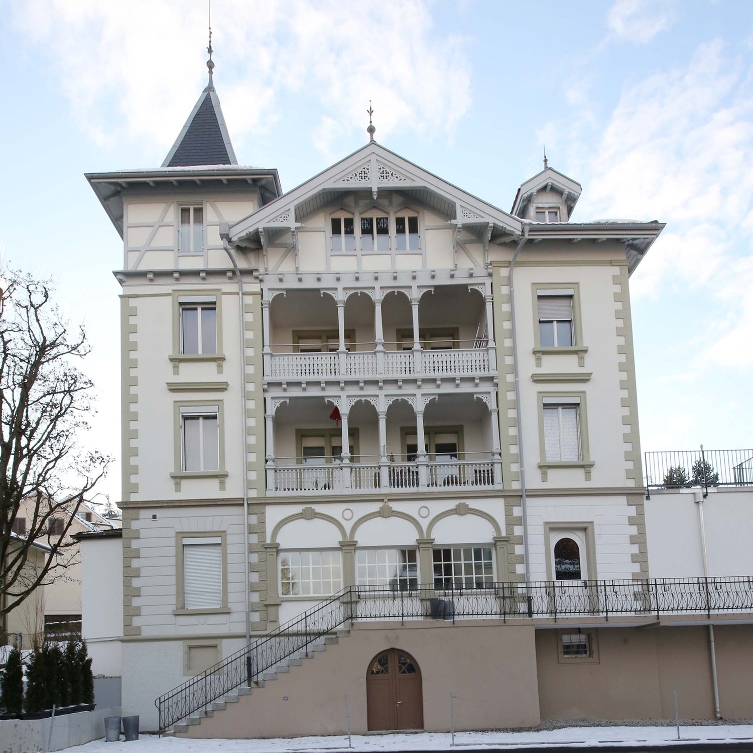 3 story house, balconies, white walls, black railings