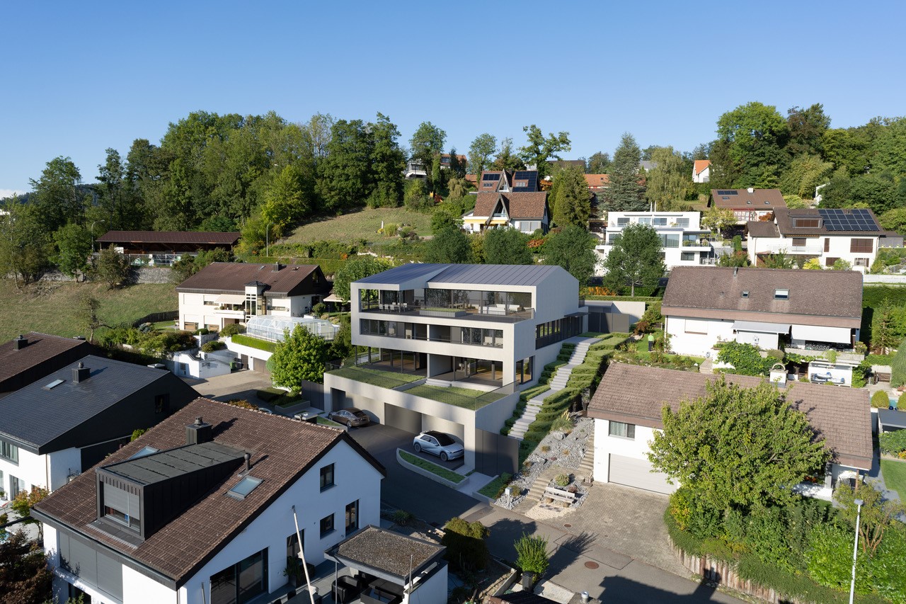 Modern multi-story residential building with parking spaces, surrounded by other houses and greenery in a residential neighborhood.