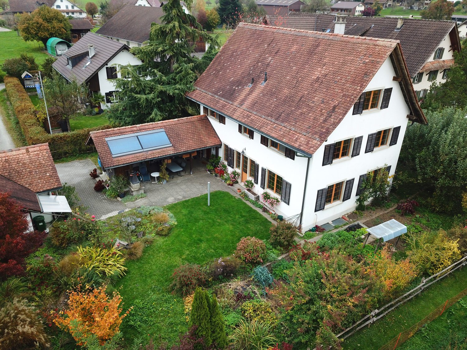 Detached house, brown roof, white walls, solar panels, attached carport, large garden, multiple windows