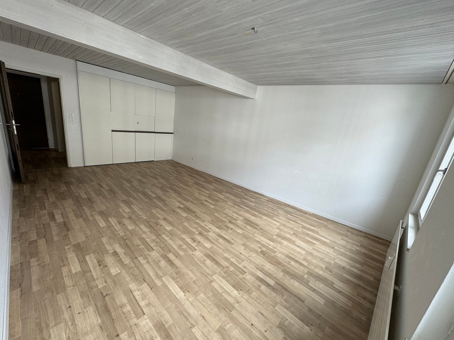 empty room, wooden floors, white walls, wooden beams, closets