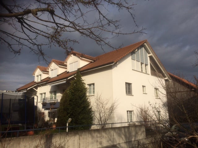 two story house, white exterior, brown roof, fenced front yard, trees, car parked in front