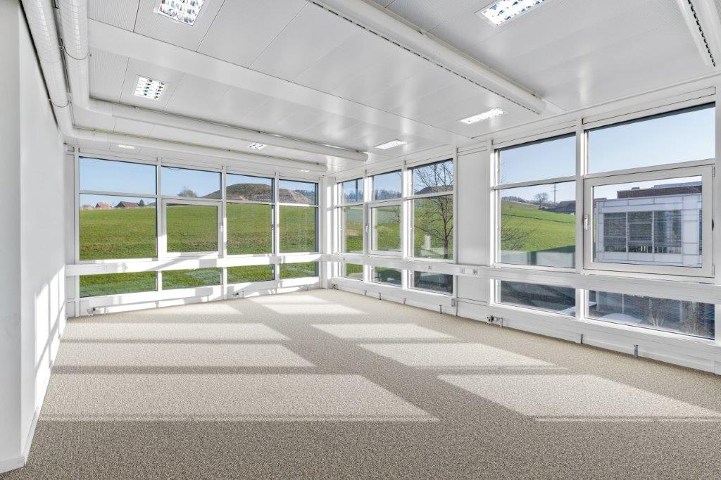 room with all white walls and large windows with view of the field