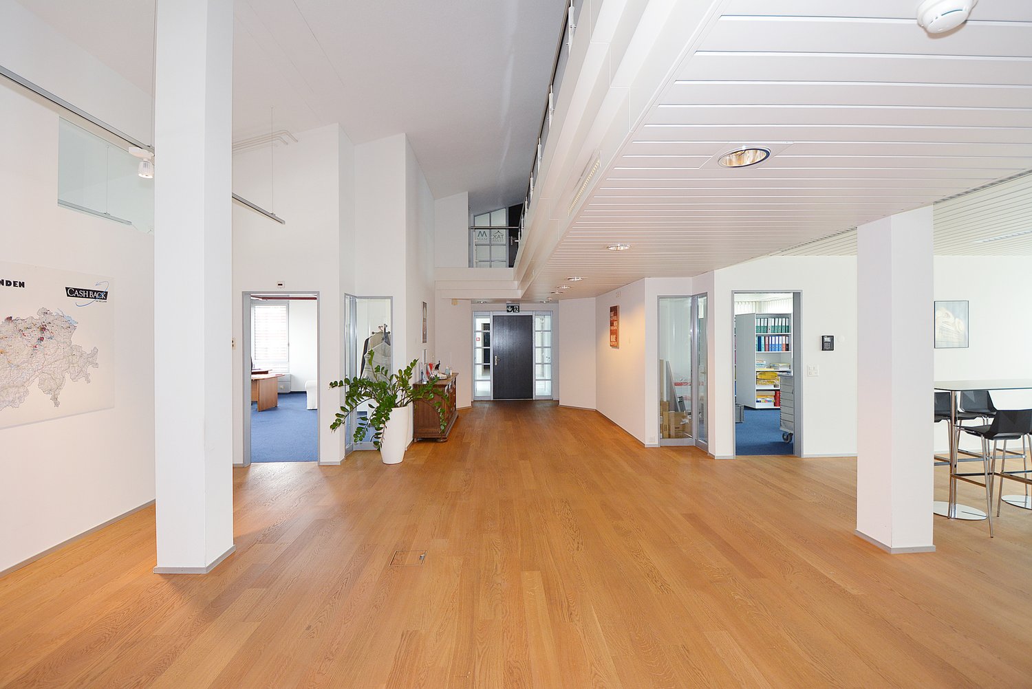 corridor, wooden floor, white walls, several rooms, table and chairs
