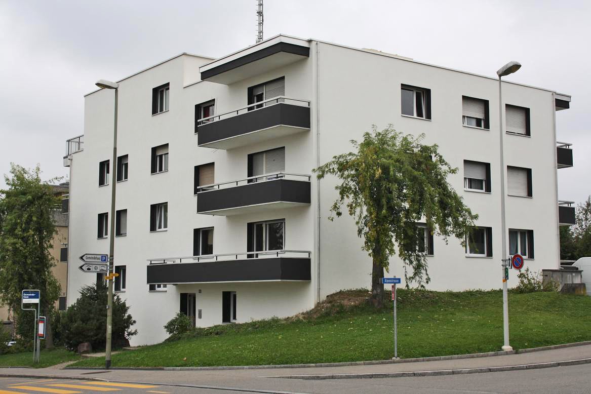 modern white building, 3 floors, balconies, green grass, street lights