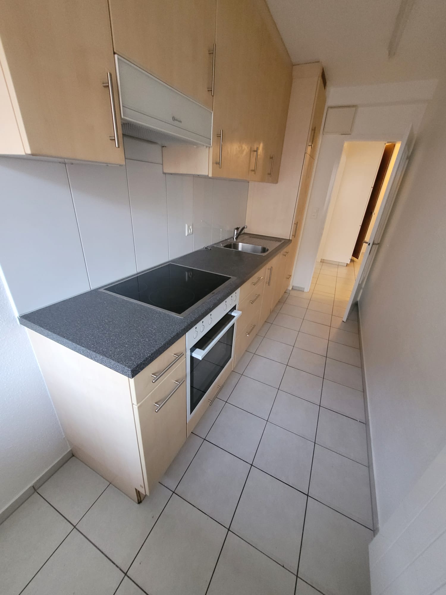 Tiled floor, cabinets, countertops, sink, electric oven, induction hob, white appliances