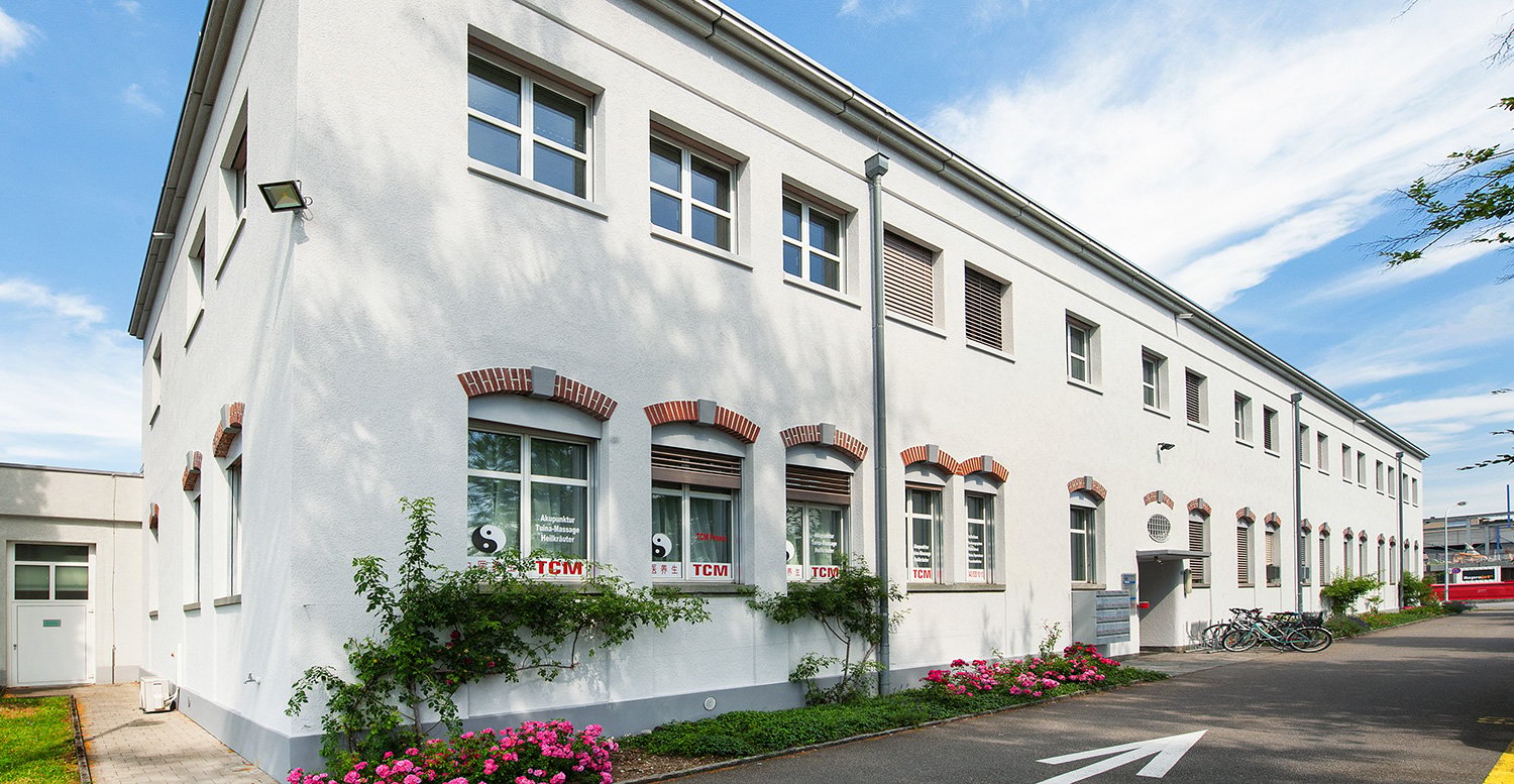 Two story white house with brick detail, multiple windows, bicycles parked in front.