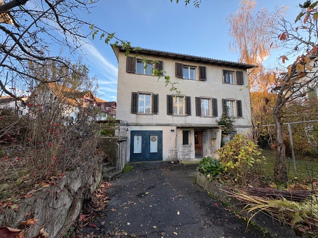 Large two-story house with white walls, large windows, garage