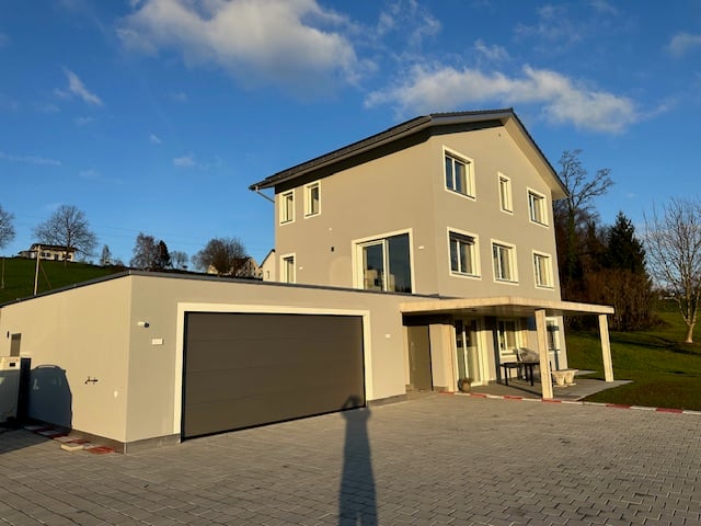 2 story house, gray exterior, garage, paved driveway, covered patio